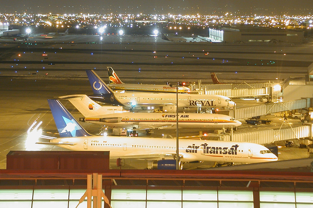 Night shot of a lineup of various aircraft parked at the gate in YYZ. Shot taken from Sheraton hotel room window in February 2001.