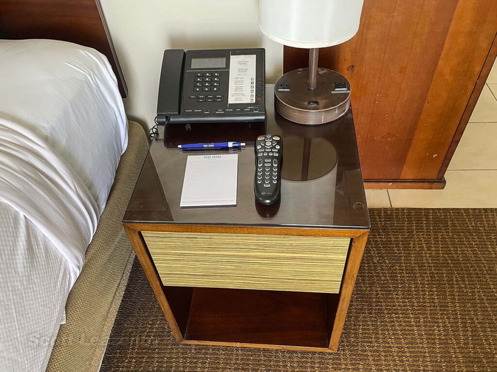 Park Shore Waikiki Hotel bedside table with phone and remote control for TV