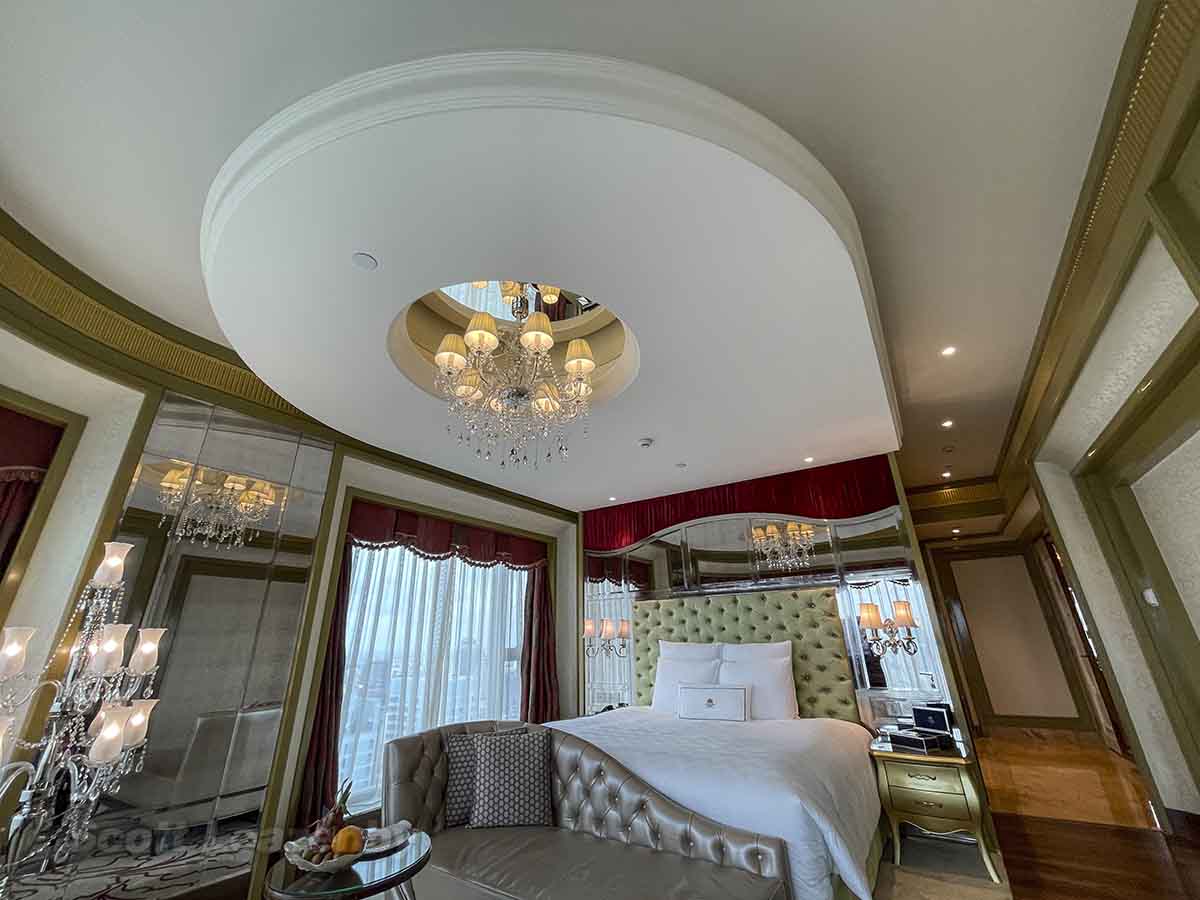 King bed and a chandelier in the panoramic room at The Reverie Saigon Hotel