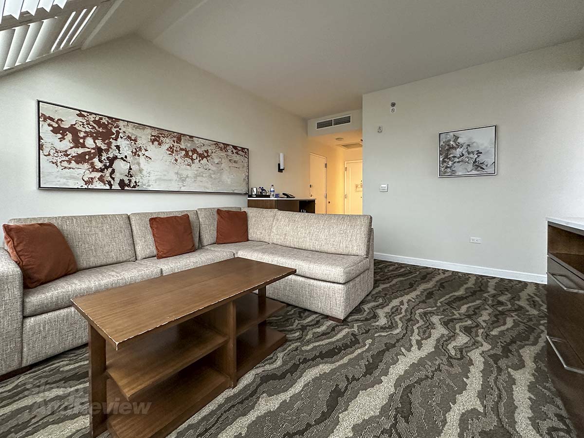 Full size couch, artwork, and coffee table in the living room in my studio suite at the Inverness Denver hotel