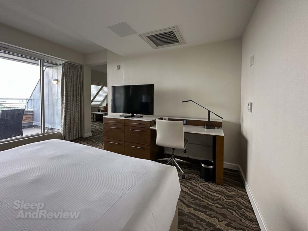 The bedroom with door to balcony in my studio suite at the Inverness Denver Hotel