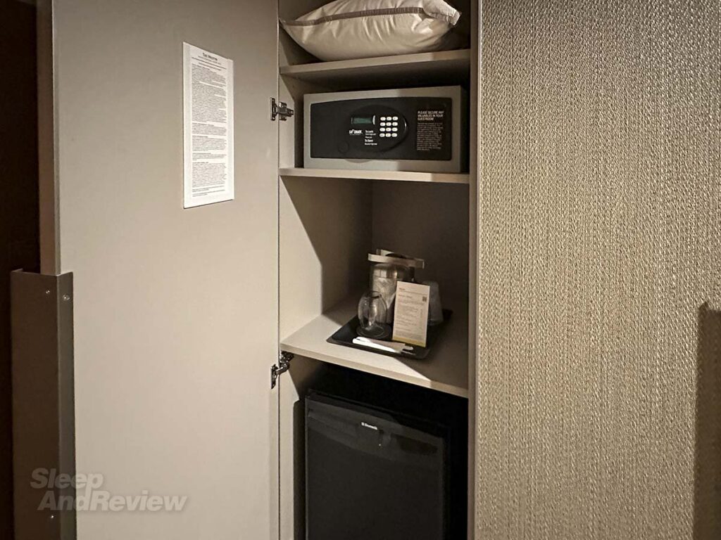 Closet with refrigerator, safe, extra pillows, and an ice bucket in my room at the West in Denver airport